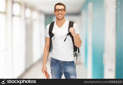 education, travel and vacation concept - smiling student in eyeglasses with backpack and book