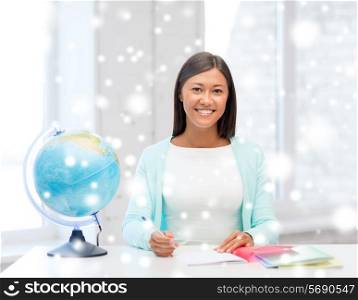 education, winter, technology and people concept - smiling young woman with globe and tablet pc computer indoors
