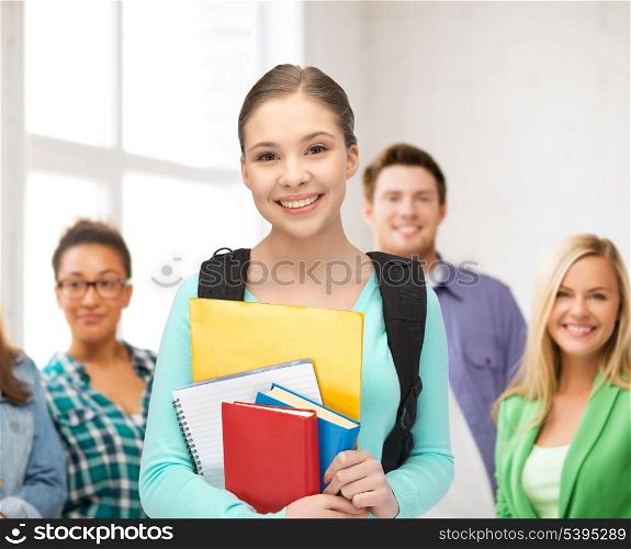 education, youth, school, teamwork concept - smiling student with books and schoolbag