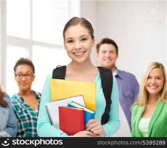 education, youth, school, teamwork concept - smiling student with books and schoolbag