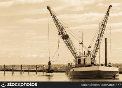 Effect vintage. Dredger ship navy working to clean a navigation channel