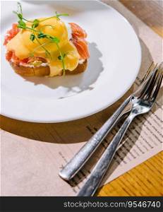 Egg benedict with hollandaise sauce and smoked salmon on toast