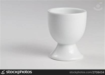 egg cup. one empty white egg cup on white background