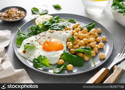 Egg fried, boiled chickpea and fresh spinach for healthy breakfast