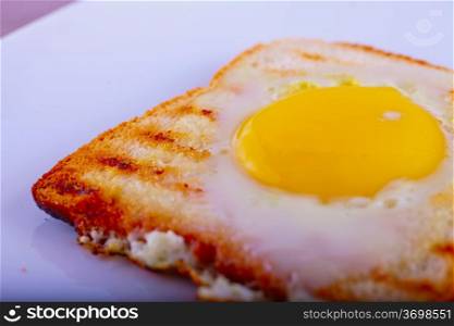 Egg-in-a-hole over white plate