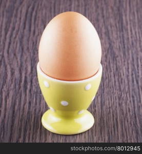 Egg in egg carrier over table, square image