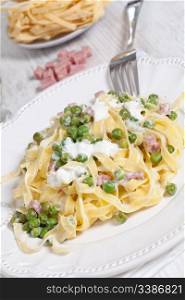 Egg noodles with cream, ham and green peas