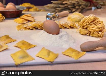 Egg on Flour, Uncooked Ravioli, Tagliatelle Italian Pasta and Cutter on White Table