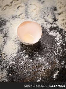 egg shell on flour and wooden background