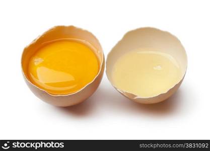 Egg yolk and white in a broken brown egg shell on white background