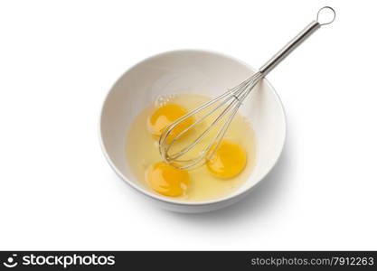 Egg yolks in a bowl with whisk on white background
