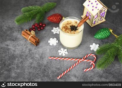 Eggnog delicious holiday drinks like themed parties with cinnamon pine cone and nutmeg for Traditional Christmas and winter holidays Homemade eggnog in glasses and candy cane decorated table