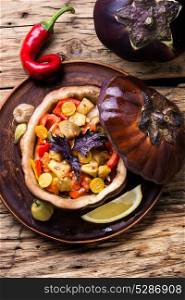 eggplant baked with vegetables. baked eggplant stuffed with vegetables on old wooden background