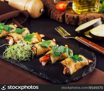 Eggplant rolls stuffed with pepper on black board