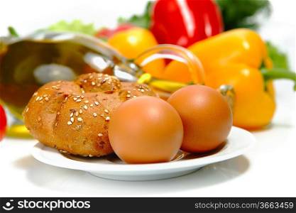 Eggs and bread, with olive oil and peopers on a white background