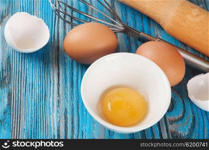Eggs and egg yolk on a blue wooden background