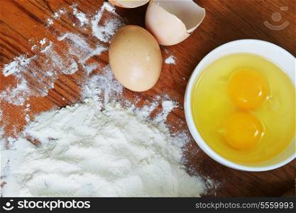 eggs and flour on wooden background