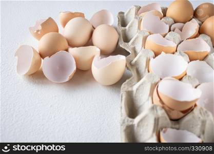 Eggs and shkarlupka eggs in a box on a white background.. Eggs and shkarlupa halves of eggs in a tray.