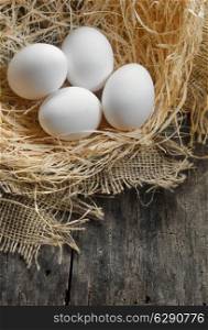 eggs at hay nest in chicken farm