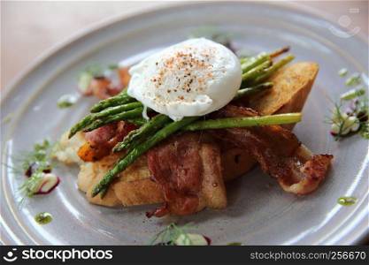 eggs benedict poached egg on bacon asparagus and bread breakfast