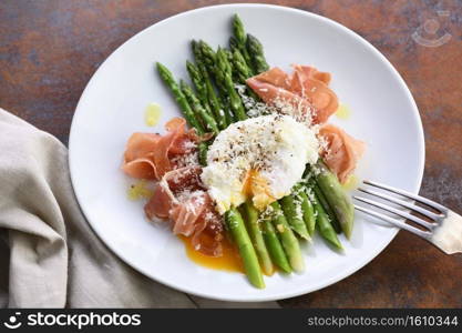 Eggs Benedict with parmesan, green asparagus and Parma ham