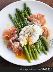 Eggs Benedict with parmesan, green asparagus and Parma ham