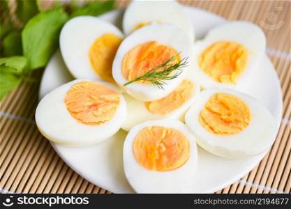 Eggs breakfast, fresh eggs menu food boiled eggs in a white plate decorated with leaves green dill background, cut in half egg yolks for cooking healthy eating