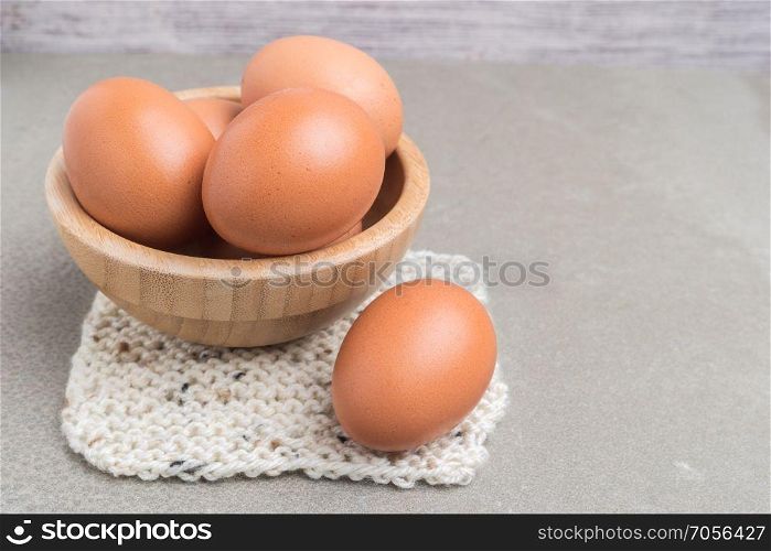 Eggs. Chicken eggs in the package on a cement background. Chicken eggs in a wodden bowl.