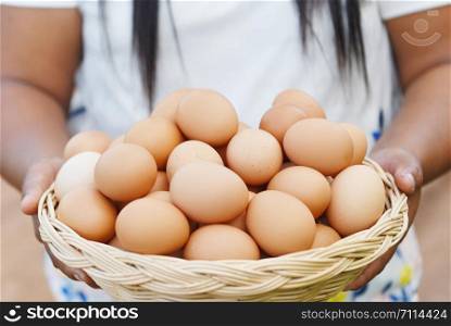 Eggs in a basket / Woman farmer holding wooden tray with fresh chicken eggs collect from farm in the countryside