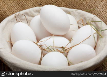 Eggs in a bowl on burlap cloth