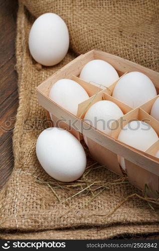 Eggs in a wooden box on burlap cloth