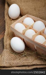 Eggs in a wooden box on burlap cloth