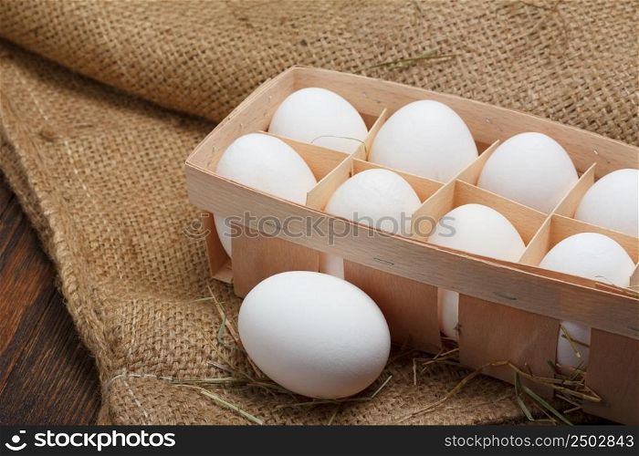 Eggs in a wooden box on burlap cloth still life