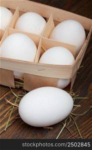 Eggs in a wooden box on wooden table