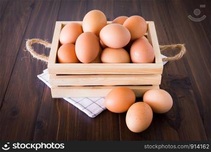 Eggs in a wooden crate on the floor, oak color.