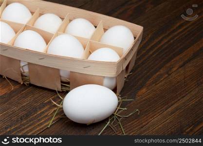 Eggs in a wooden tray on wooden table
