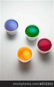 Eggs in cups of paint