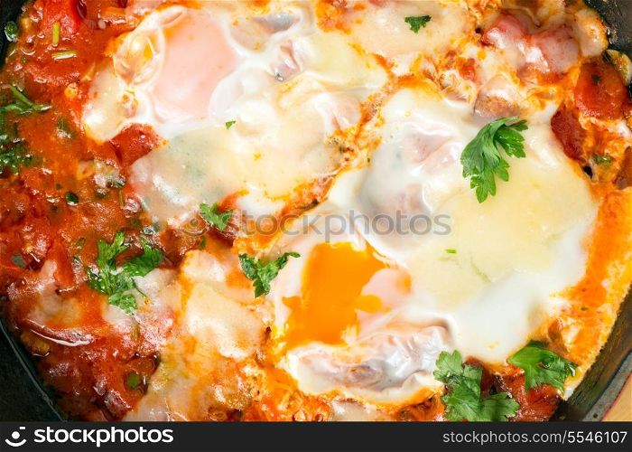 ""Eggs in Purgatory", a traditional Mediterranean breakfast dish of eggs poached over a spicy tomato sauce topped with melted cheese."