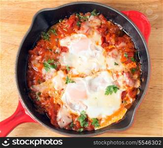 ""Eggs in Purgatory", a traditional Mediterranean breakfast dish of eggs poached over a spicy tomato sauce topped with melted cheese."