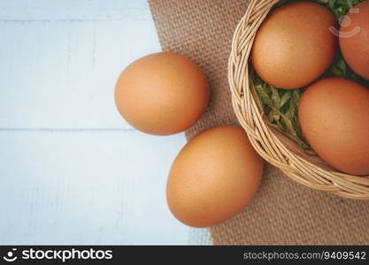 Eggs in the wicker basket on white wooden background for healthy food concept