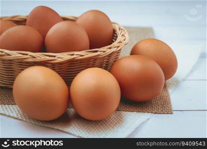 Eggs in the wicker basket on white wooden background for healthy food concept