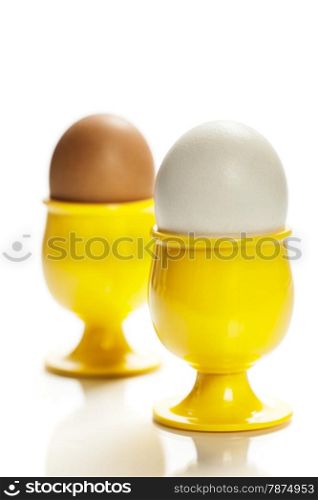 eggs in yellow eggcups isolated on white