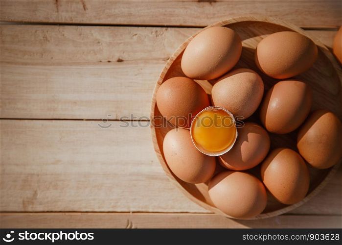 Eggs lay on wooden trays and have broken eggs.