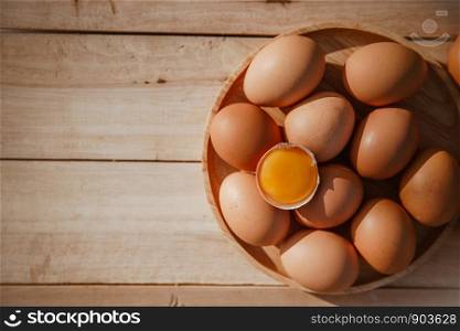 Eggs lay on wooden trays and have broken eggs.