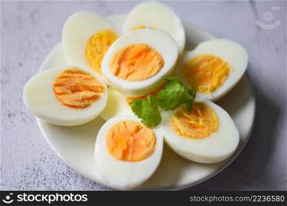 Eggs menu food boiled eggs in a white plate decorated with leaves green coriander, cut in half egg yolks for cooking healthy eating eggs breakfast