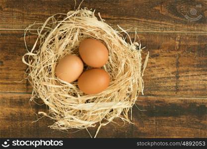 Eggs on straw placed on a wooden table