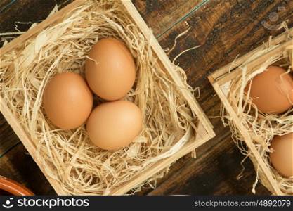 Eggs on straw placed on a wooden table