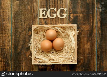 Eggs on straw placed on a wooden table