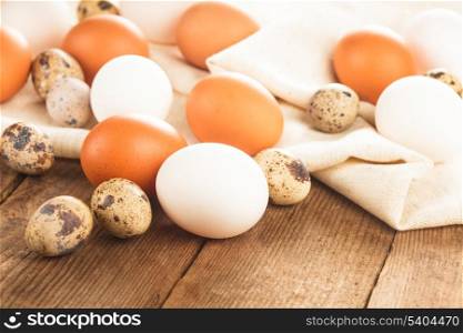 Eggs on textile tablecloth over rustic wooden table