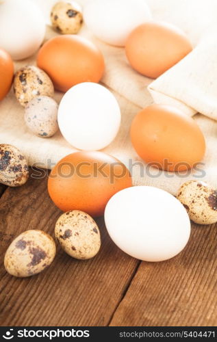 Eggs on textile tablecloth over rustic wooden table